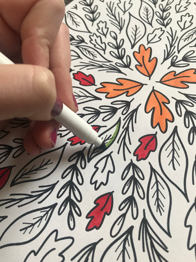 woman coloring with markers on Fall coloring page